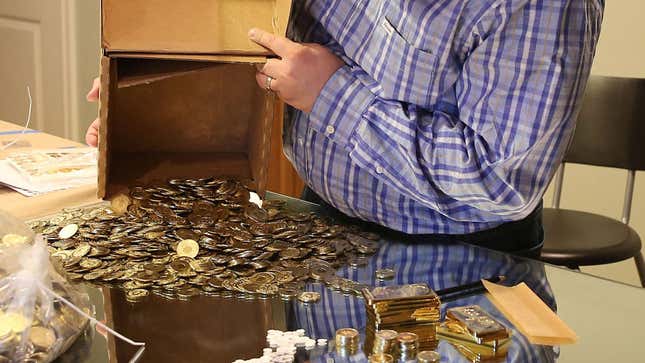 A man dumps homemade bitcoins onto a glass table.