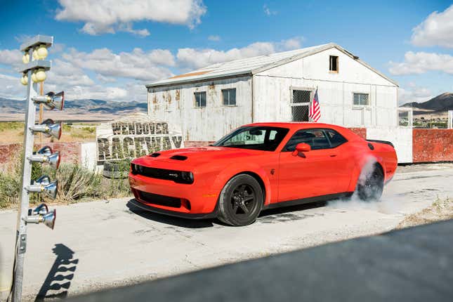 Big silly red car doing a big, loud and smoky burnout.