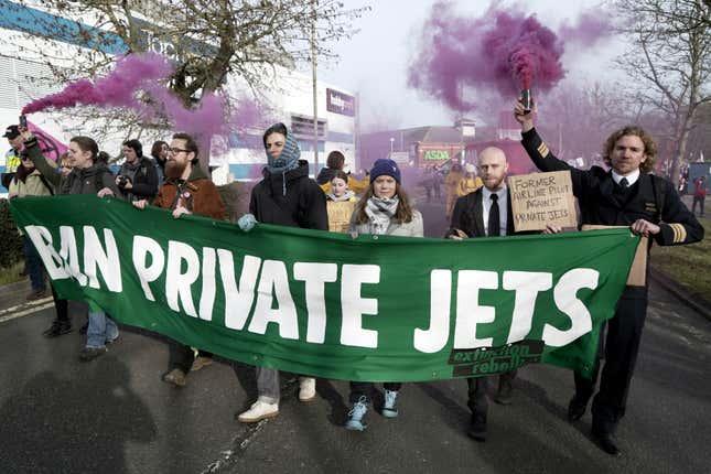 In this photo issued by Extinction Rebellion UK, climate activist Greta Thunberg, third right, takes part in a march to Farnborough Airport in southern England, Saturday Jan. 27, 2024. Greta Thunberg joined the march to protest the use of private jets and the expansion of an airport. Hundreds of local residents and activists holding banners and placards took part. (Extinction Rebellion UK via AP)