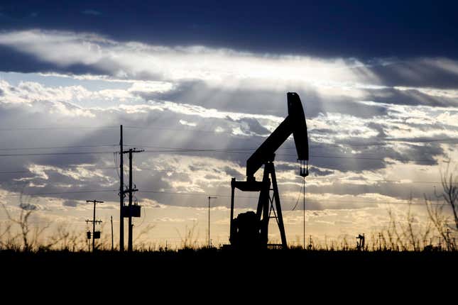 FILE - The sun shines through the clouds as it begins to set behind a pumpjack, March 30, 2022, outside of Goldsmith, Texas. In an agreement announced Tuesday, Feb. 13, 2024, Apache Corporation has reached a multimillion-dollar settlement with the federal government and the state of New Mexico to address air pollution concerns in the largest oil and gas producing region in the United States. (Eli Hartman/Odessa American via AP, File)