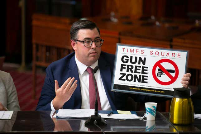 Robert Barrows of the New York City Police Department holds up a “gun-free zone” sign during a City Council meeting Tuesday, Aug. 30, 2022