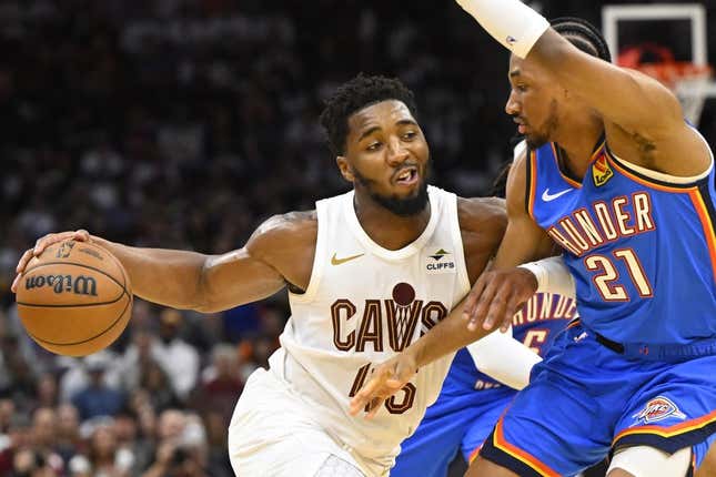 Oct 27, 2023; Cleveland, Ohio, USA; Cleveland Cavaliers guard Donovan Mitchell (45) drives against Oklahoma City Thunder guard Aaron Wiggins (21) in the fourth quarter at Rocket Mortgage FieldHouse.