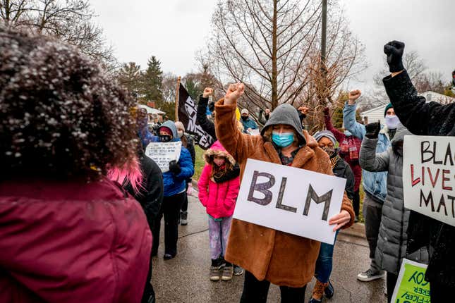 Shawn Finley, a resident and protest organizer, holds a BLM sign and raises her fist along with protesters in a demonstration against the police killing of Andre Hill in the neighborhood where Hill was shot, in Columbus, Ohio on December 24, 2020. - The killing of an unarmed African-American man by police in the US city of Columbus, Ohio sparked a fresh wave of outrage this week against racial injustice and police brutality in the country. Andre Maurice Hill, 47, was in the garage of a house on the night of December 21 when he was shot several times by a police officer who had been called to the scene for a minor incident.