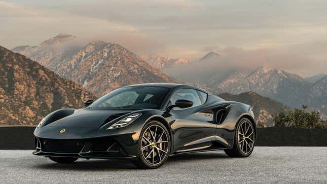 A dark verdant green Lotus Emira parked in front of a view of the Angeles mountains