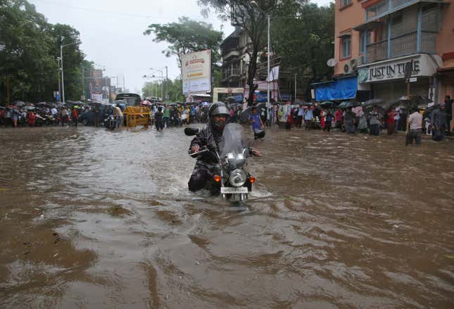 A man rides his motorbike through a water-logged road in Mumbai.