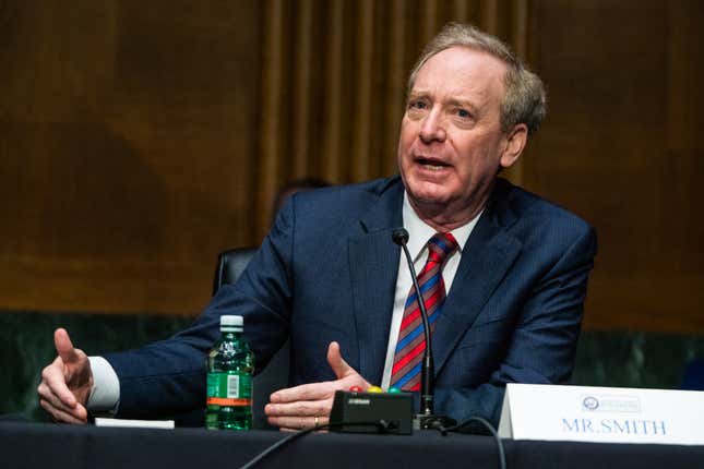 Microsoft President Brad Smith talks with his hands out on the table.