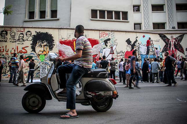 An onlooker watches graffiti artists.