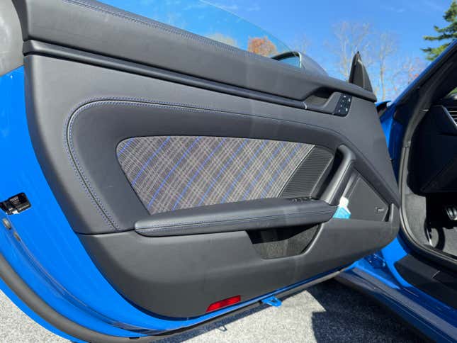 Door panel of a blue 2025 Porsche 911 Carrera T cabriolet