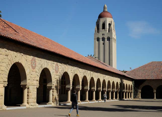 FILE - People walk on the Stanford University campus beneath Hoover Tower, March 14, 2019, in Stanford, Calif. Following a lawsuit filed Monday, Sept. 18, 2023, that alleges Stanford University received millions of dollars in donations from FTX Trading, the school said Wednesday, Sept. 20, that it will return the funds of all gifts collected from the now-collapsed cryptocurrency exchange. (AP Photo/Ben Margot, File)