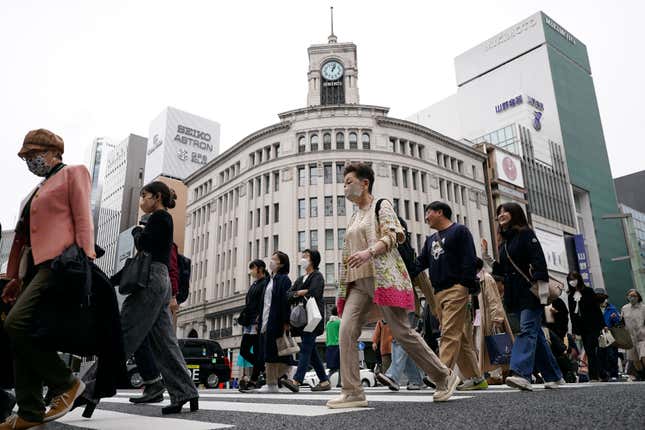 FILE - People walk across a pedestrian crossing in Ginza shopping district in Tokyo on March 31, 2023. Japan’s economy slipped into a contraction in the third quarter, decreasing at an annual pace of 2.1% as consumption and investments shrank, the government reported Wednesday, Nov. 15, 2023. (AP Photo/Eugene Hoshiko, File)