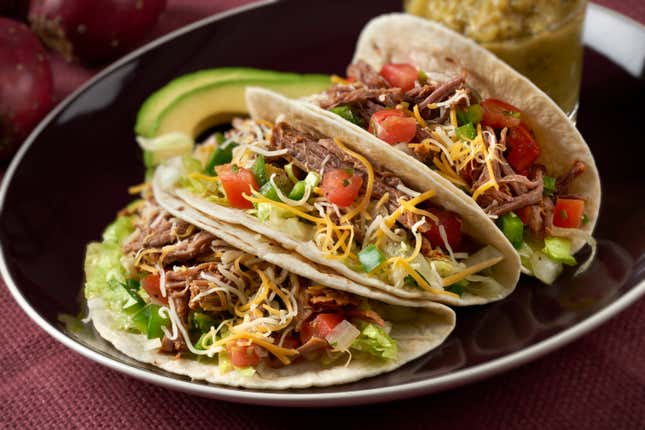 Three beef tacos in soft tortillas.