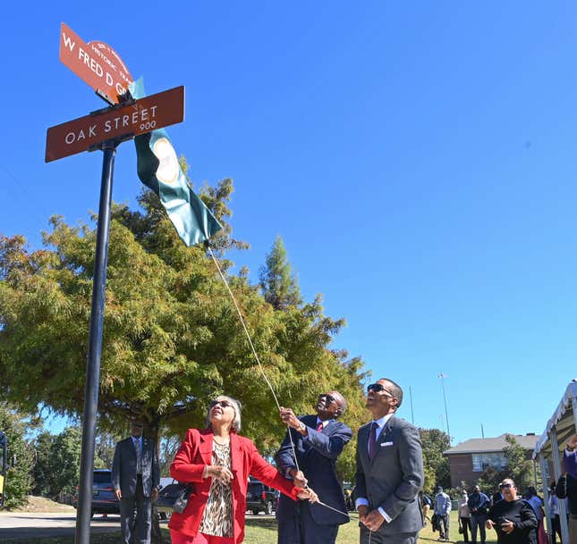 Civil Rights attorney Fred Gray, (C), unveils the new street sign bearing his name alongside his wife Carol, (L), and Montgomery Mayor Steven Reed, (R).