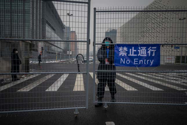 A security guard closes the gate in the fence that delimitates the area not accessible to the general public, that will host Beijing 2022 Winter Olympics is seen at Olympic Park on January 23, 2022 in Beijing, China. 