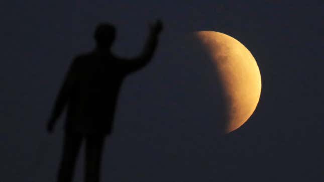 The partial lunar eclipse of July 16, 2019 as seen in Brazil, with a statue in the foreground. 