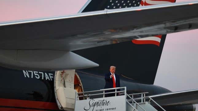 a photo of trump entering the rear door of his plane giving the camera a thumbs up