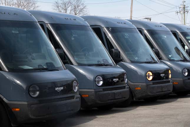 Amazon delivery trucks built by Rivian sit in a lot at a Rivian facility in February 22, 2024 in Chicago, Illinois. 