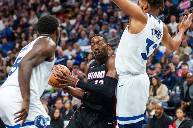 Oct 28, 2023; Minneapolis, Minnesota, USA; Miami Heat center Bam Adebayo (13) drives to the basket as Minnesota Timberwolves center Karl-Anthony Towns (32) and guard Anthony Edwards (5) defend in the second quarter at Target Center.