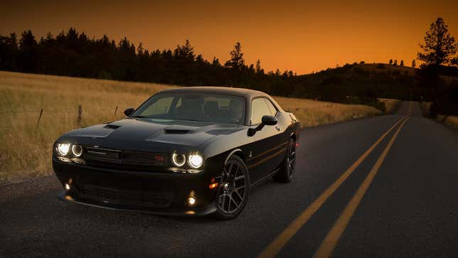 A photo of a black Dodge Challenger muscle car at sunset. 