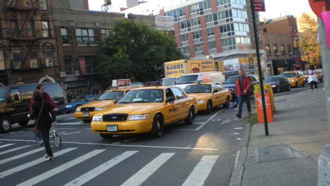 Three Ford Crown Victoria taxis waiting at an intersection
