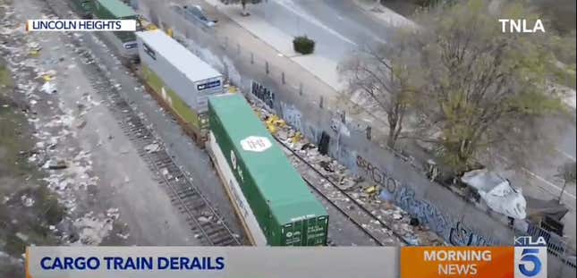 A cargo train is derailed and surrounded by trash in Los Angeles