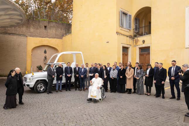 The Pope with a crowd in front of the new Popemobile