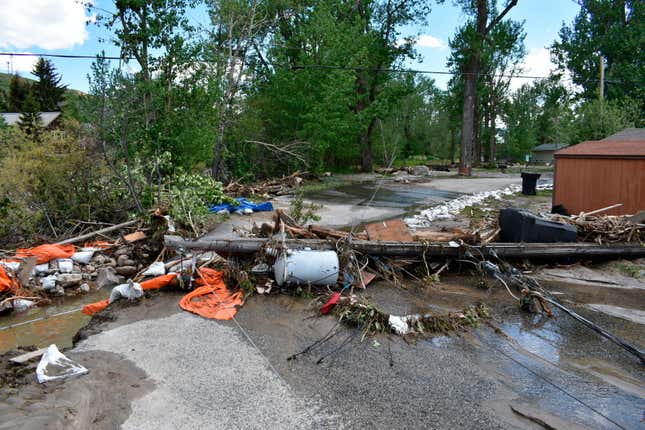 Debris is seen blocking a street in Red Lodge, Montana, on Tuesday, June  14, 2022, after floodwaters coursed through a neighborhood with  hundreds of houses the day before.