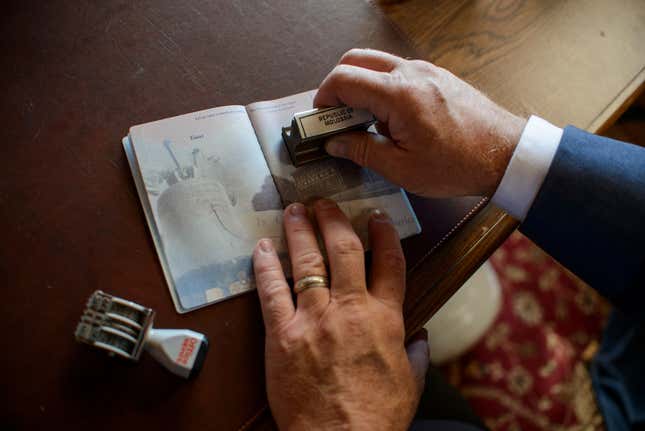 President Baught stamps a passport with the official Molossian stamp.