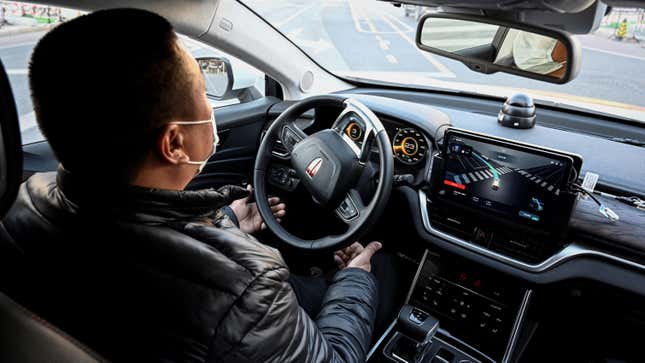 A driver in China demonstrates the functionality of an autonomous taxi.