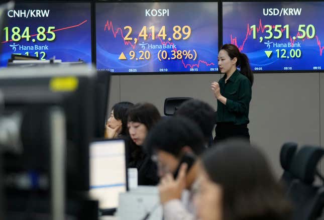 A currency trader passes by the screens showing the Korea Composite Stock Price Index (KOSPI), center, and the foreign exchange rate between the U.S. dollar and South Korean won, right, at the foreign exchange dealing room of the KEB Hana Bank headquarters in Seoul, South Korea, Thursday, Oct. 5, 2023. Asian shares mostly rose Thursday, boosted by a cheaper yen that&#39;s a plus for exporting economies in the region, although it recovered slightly in Asian trading. (AP Photo/Ahn Young-joon)