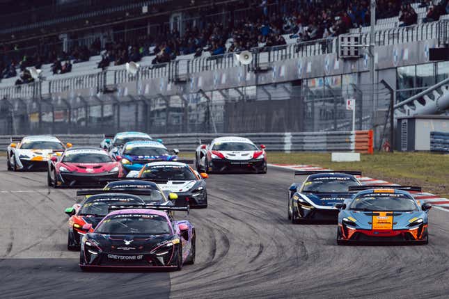 A lineup of colorful McLaren race cars on track
