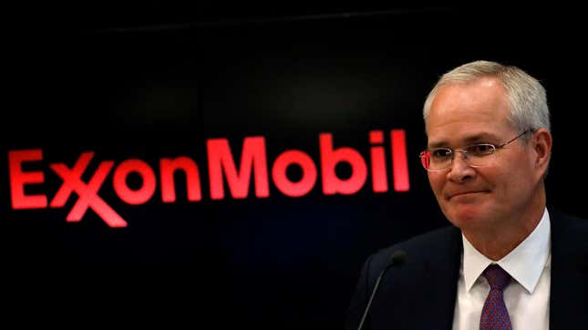 DarrenWoods, président-directeur général d’ExxonMobil à côté du logo rouge de l’entreprise sur fond noir