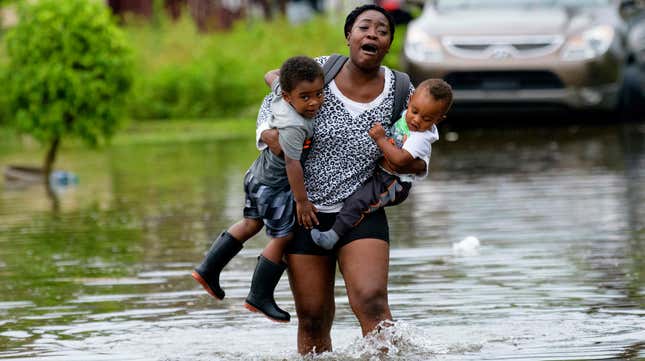 Terrian Jones feels something move in the water as she brings these two boys to their mother during the storm in New Orleans on July 10, 2019.