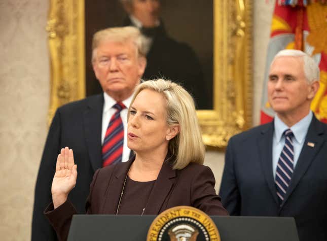 United States Secretary of Homeland Security (DHS) Kirstjen Nielsen, center, administers the oath of citizenship to five people as U.S. President Donald Trump, left, and Vice President Mike Pence, right look on during a naturalization ceremony in the Oval Office of the White House in Washington, DC on Saturday, January 19, 2019.