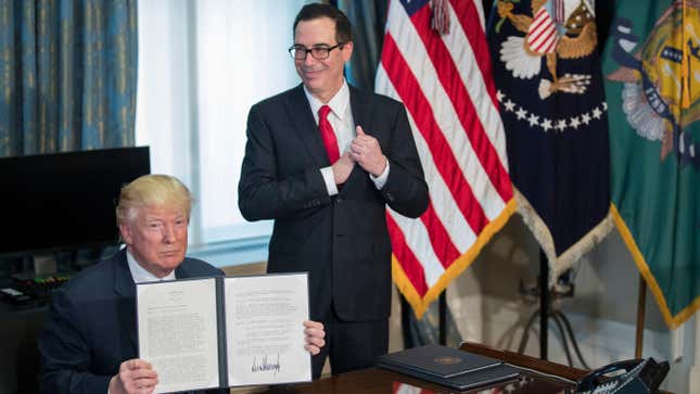 U.S. President Donald Trump (L), with Secretary of Treasury Steven Mnuchin (R), participate in a financial services Executive Order signing ceremony in the US Treasury Department building on April 21, 2017 in Washington, DC. President Trump is making his first visit to the Treasury Department for a memorandum signing ceremony with Secretary Mnuchin. 