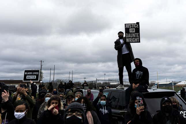 People gather holding signs and flags before curfew to protest the death of Daunte Wright who was shot and killed by a police officer in Brooklyn Center, Minnesota on April 12, 2021. 