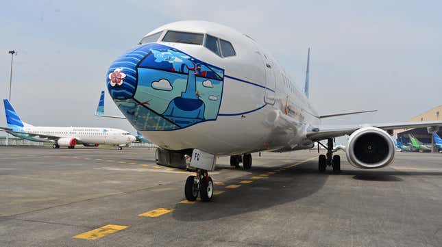 A Garuda Indonesia Boeing 373-800 NG with a new face mask design as part of a campaign to promote the wearing of face masks amid the COVID-19 coronavirus, is parked at the airport in Tangerang on October 12, 2020. 
