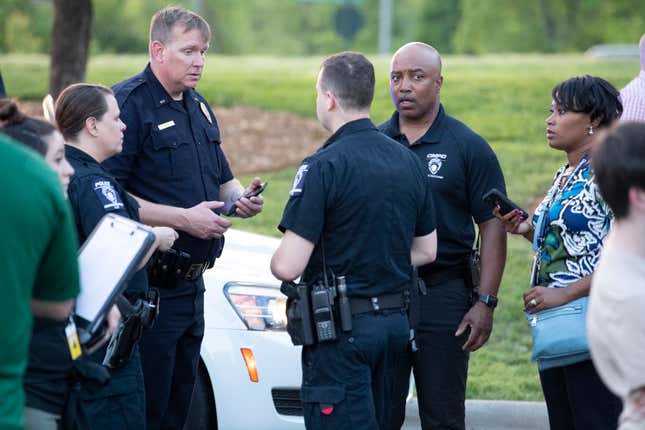 People gather across from the campus of UNC Charlotte after a shooting incident at the school Tuesday, April 30, 2019, in Charlotte, N.C.