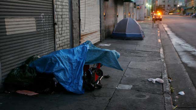 People sleep on the sidewalk in Los Angeles, California, on April 19, 2006.