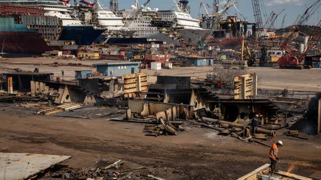 A man works at a ship recycling yard in front of five luxury cruise ships that are being broken down for scrap metal at the Aliaga ship recycling port on October 02, 2020 in Izmir, Turkey. 