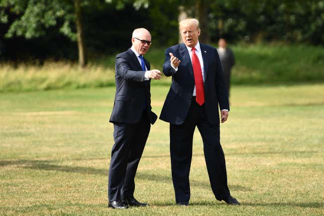 US President Donald Trump (R) gestures as he talks with US Ambassador to the United Kingdom Woody Johnson (L) preparing to board Marine One to depart the US ambassador’s residence Winfield House in London on July 13, 2018. - 