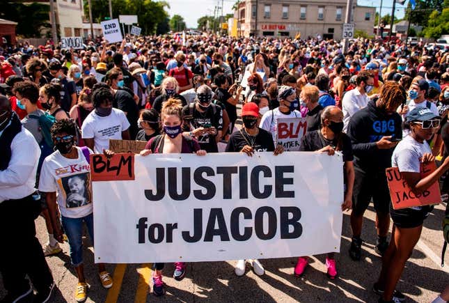 Protesters march with the family of Jacob Blake during a rally against racism and police brutality in Kenosha, Wisconsin, on August 29, 2020. - Demonstrations have been ongoing since Jacob Blake was shot by Kenosha Police officer Rusten Sheskey on August 23. 