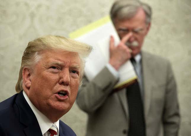 President Donald Trump speaks to members of the media as former National Security Adviser John Bolton listens.