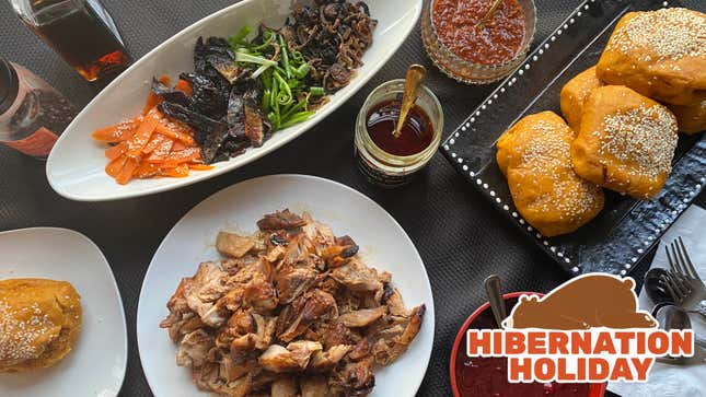 Overhead view of servings of rolls, sliced turkey, vegetables, and sauces arranged on a table