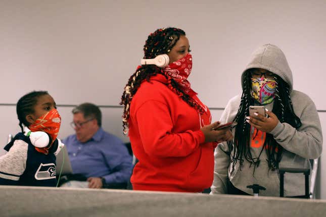 Travelers wait for luggage wearing face protection at Sky Harbor Airport on March 12, 2020 in Phoenix, Arizona.