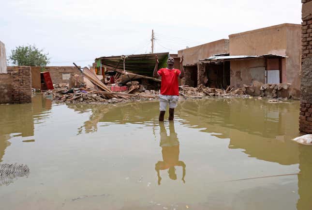 A man gestures as he wades through a flooded road in the town of Salmaniya, about 25 miles (35 km) southwest of the capital, Khartoum, Sudan, Thursday, Sept. 17, 2020. 