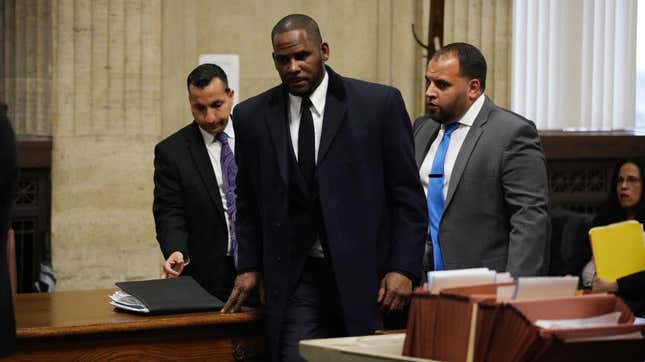 R. Kelly (center) appears in court in Chicago May 7, 2019, on sex assault charges he faces. On May 30, 2019, prosecutors hit the singer with a whole new slate of sex abuse charges. 