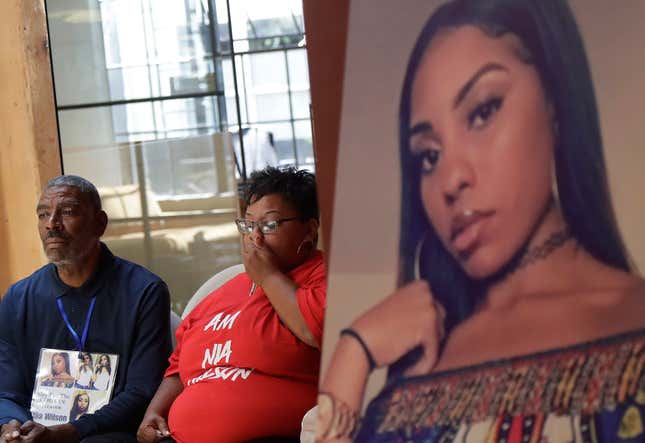 A photo of stabbing victim Nia Wilson, right, is displayed at a news conference as her father Ansar El Muhammad, left, and her mother Alicia Grayson listen during a news conference in San Francisco.