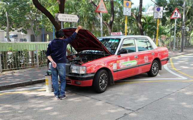 Photo: Michael TracyMechanics doing some sort of fluid replacement on a Toyota Crown taxi.