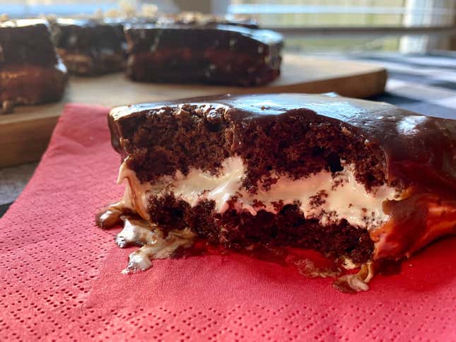 Closeup of a serving of Jos Louis cake with a bite taken out to show cross-section