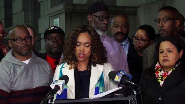 Baltimore State’s Attorney Marilyn Mosby, center, flanked by Andrew Steward, left, Ransom Watkins (behind Mosby) and Alfred Chestnut (green jacket).